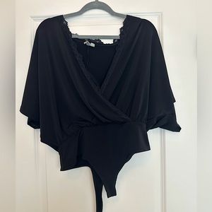NEVER worn ASOS bodysuit in black. Deep V neck/opening with lace trim
